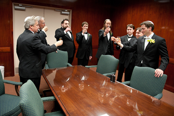 groomsmen taking shots in an office board room setting -photo by Houston based wedding photographer Adam Nyholt